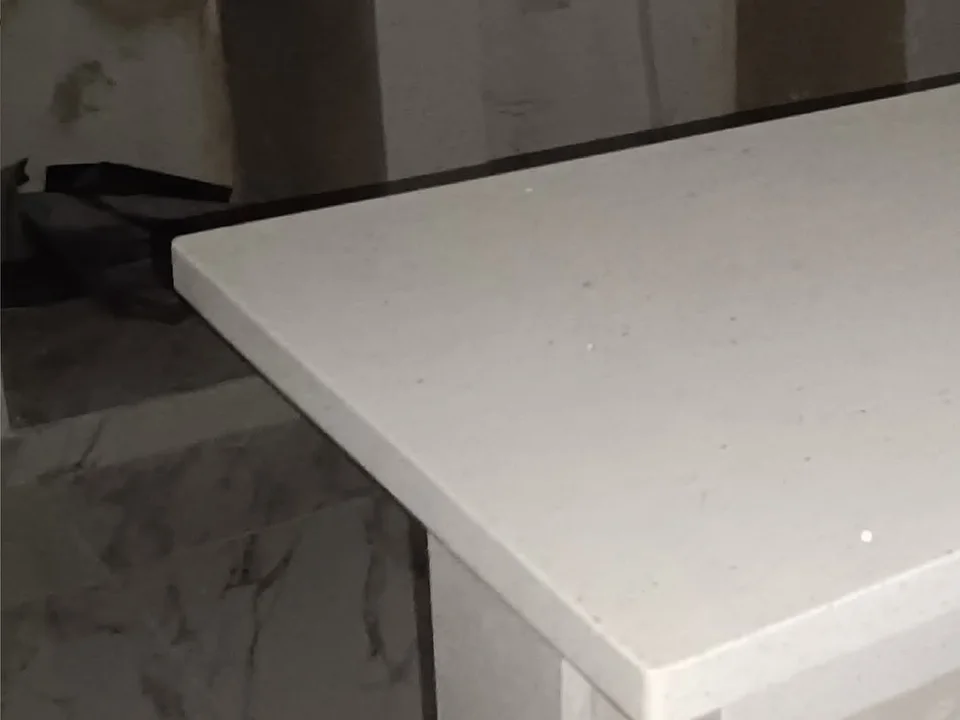 Barra clara de cuarzo blanco con canto recto en una instalación interior.